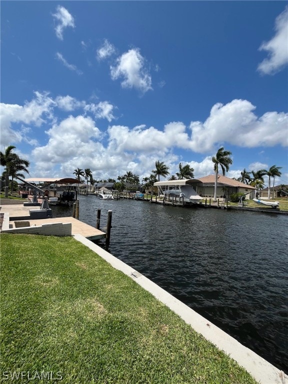 dock area featuring a water view and a lawn