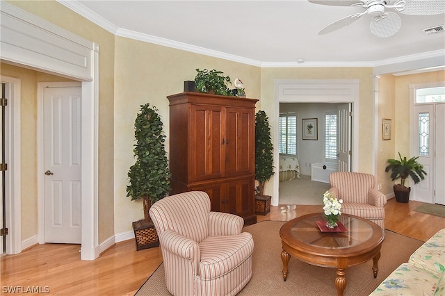 sitting room featuring ornamental molding, ceiling fan, a healthy amount of sunlight, and light wood-type flooring