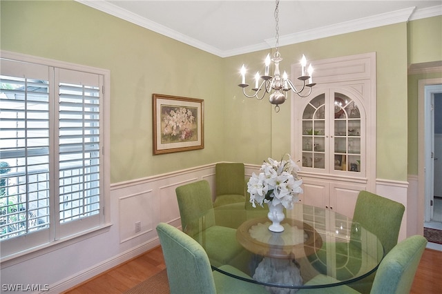 dining space featuring an inviting chandelier, hardwood / wood-style flooring, and ornamental molding