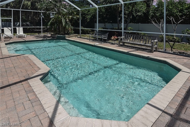 view of swimming pool with a patio and a lanai