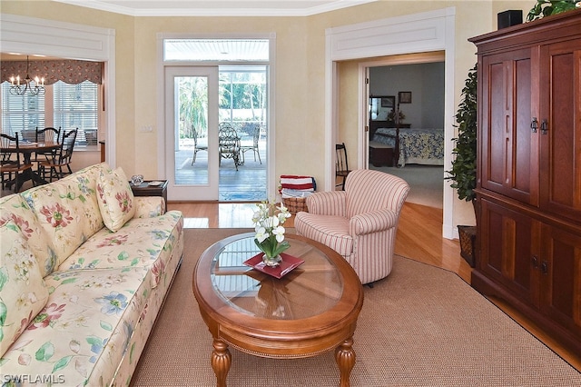 living room featuring ornamental molding, an inviting chandelier, and light wood-type flooring