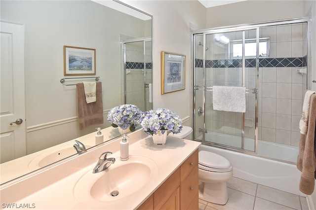 full bathroom featuring vanity with extensive cabinet space, enclosed tub / shower combo, toilet, and tile floors