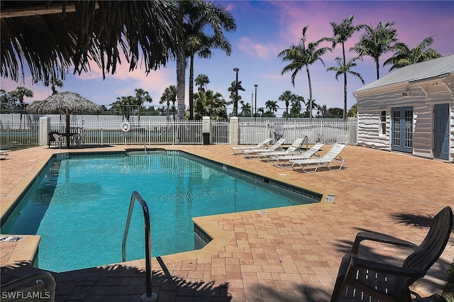 12660 Coconut Creek Ct, Fort Myers, FL 33908 - pool at dusk with french doors and a patio area