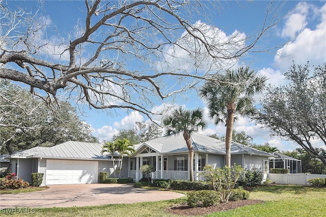 ranch-style house featuring a garage, a lanai, a front yard, and covered porch