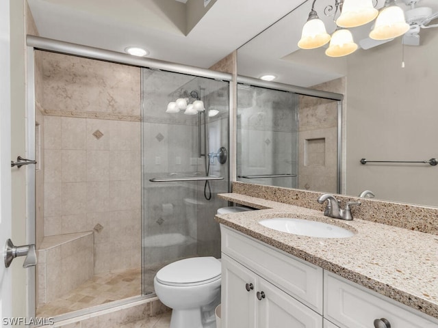 bathroom featuring oversized vanity, a shower with shower door, tile floors, and toilet