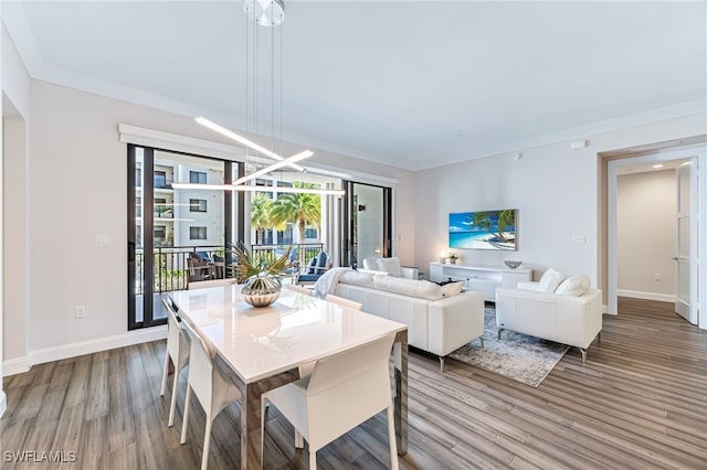 dining space with wood-type flooring and crown molding