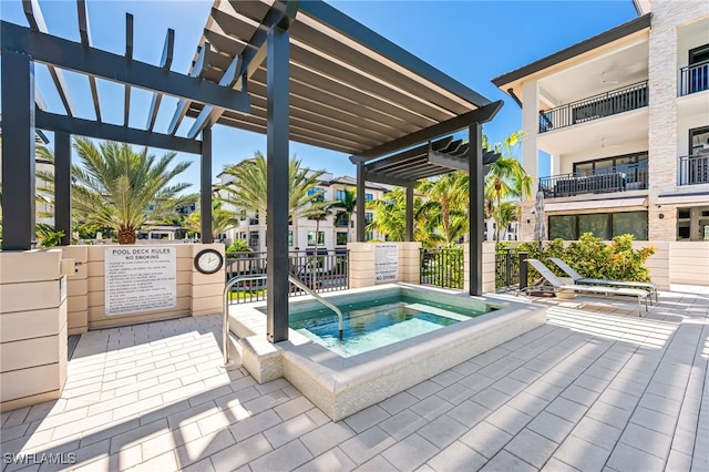 view of swimming pool with a pergola and a hot tub