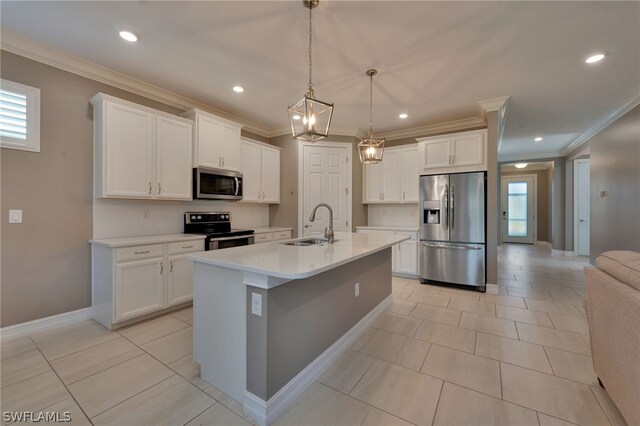 kitchen with appliances with stainless steel finishes, a center island with sink, white cabinetry, sink, and pendant lighting