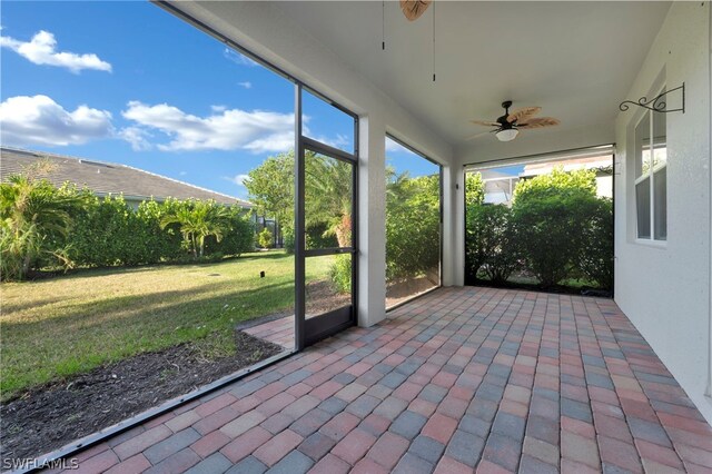 unfurnished sunroom featuring ceiling fan