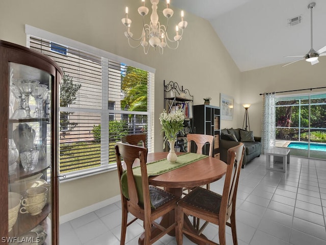 dining room with a healthy amount of sunlight, high vaulted ceiling, ceiling fan with notable chandelier, and tile flooring