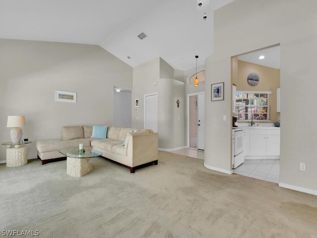 carpeted living room with high vaulted ceiling and sink