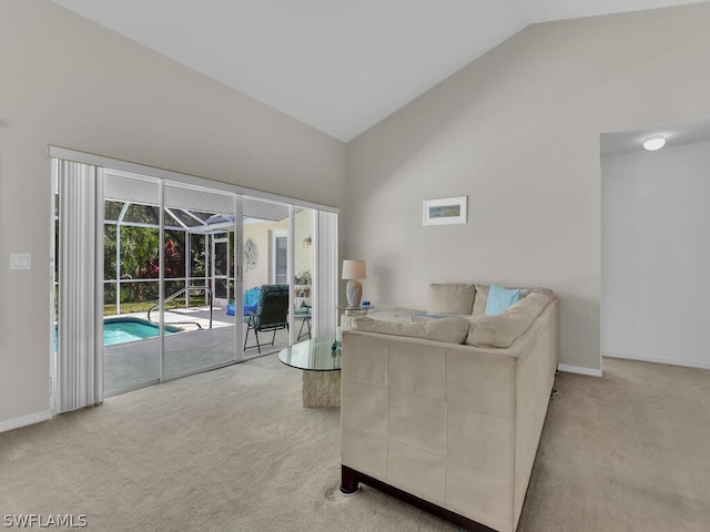 carpeted living room with high vaulted ceiling