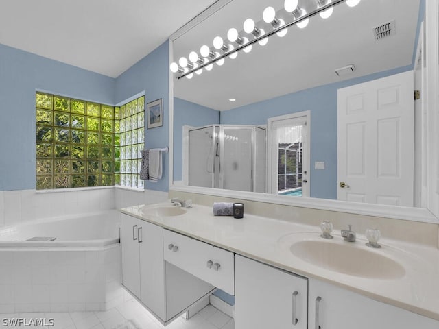 bathroom featuring dual sinks, large vanity, tile floors, and plus walk in shower