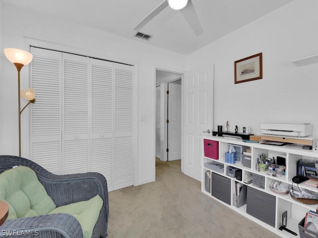 sitting room featuring ceiling fan and light carpet