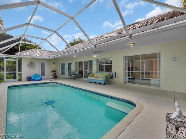 view of swimming pool featuring a patio area and glass enclosure