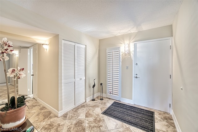 tiled entrance foyer featuring a textured ceiling