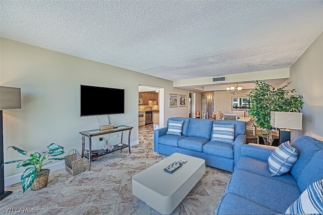 living room featuring light tile flooring, a chandelier, and a textured ceiling