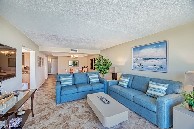 living room featuring a textured ceiling, an inviting chandelier, and light tile floors