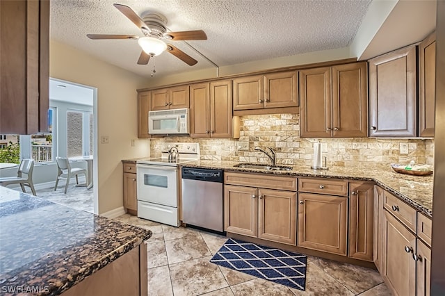 kitchen featuring ceiling fan, range, sink, stainless steel dishwasher, and light stone countertops