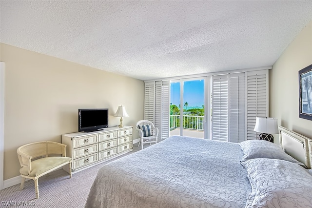 bedroom featuring light carpet and a textured ceiling