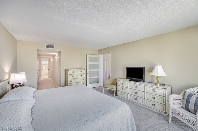 carpeted bedroom featuring a textured ceiling