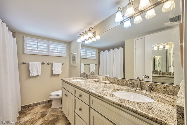 bathroom featuring toilet, tile flooring, and double sink vanity