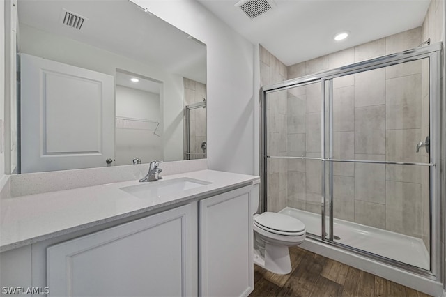 bathroom with vanity, hardwood / wood-style floors, toilet, and walk in shower