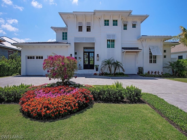 view of front of house featuring french doors, a front lawn, and a garage