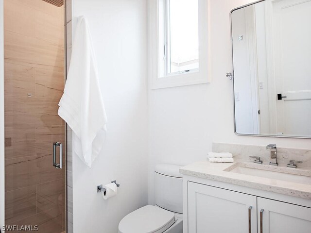 bathroom featuring vanity, toilet, and an enclosed shower