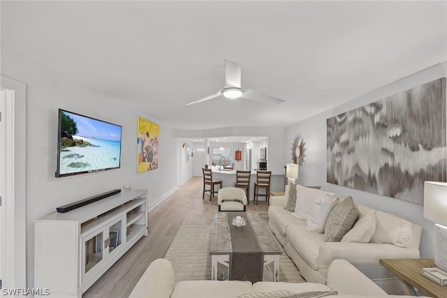 living room featuring ceiling fan and light wood-type flooring