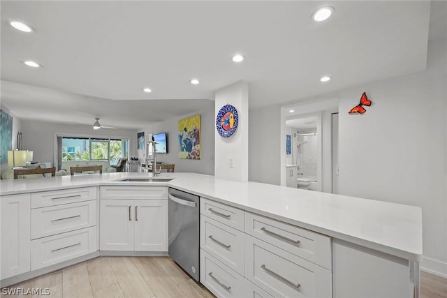 kitchen featuring sink, white cabinets, stainless steel dishwasher, ceiling fan, and kitchen peninsula