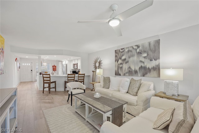 living room with ceiling fan and light wood-type flooring