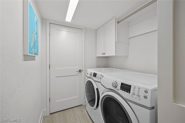 laundry room with cabinets, independent washer and dryer, and light hardwood / wood-style floors