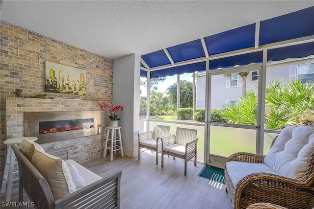 sunroom / solarium featuring a brick fireplace