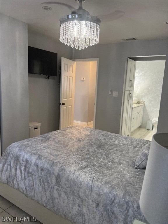 bedroom with an inviting chandelier, connected bathroom, and light tile floors