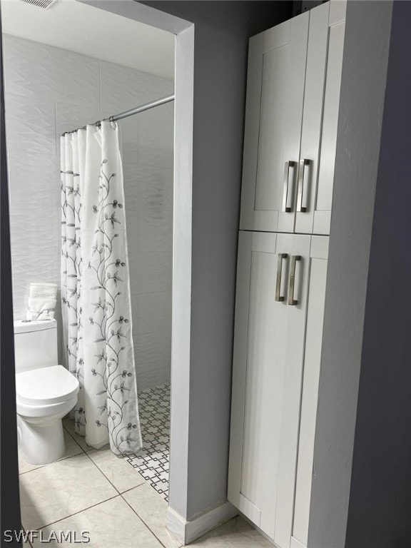 bathroom with a shower with shower curtain, toilet, and tile flooring