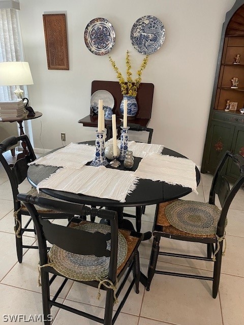 dining room with light tile patterned floors and arched walkways