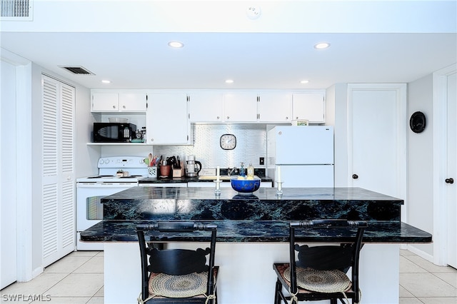 kitchen with white cabinetry, white appliances, light tile floors, and tasteful backsplash