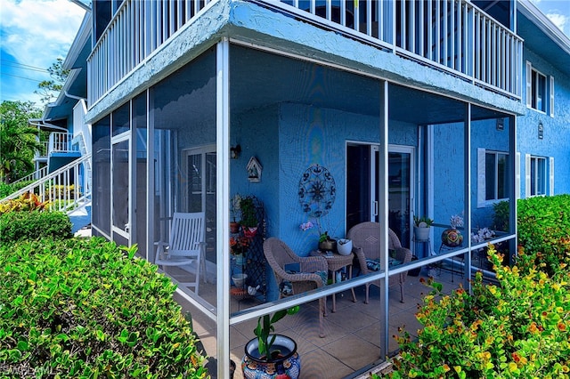 exterior space with a sunroom and a balcony