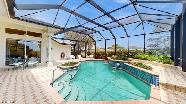 view of swimming pool featuring glass enclosure, ceiling fan, a patio area, and pool water feature