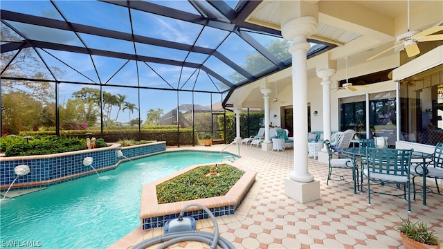 view of pool featuring glass enclosure, outdoor lounge area, ceiling fan, pool water feature, and a patio