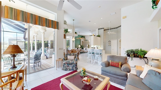 living room with ceiling fan, light tile patterned floors, and a high ceiling