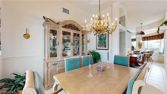 dining room with light tile patterned floors, high vaulted ceiling, and a chandelier