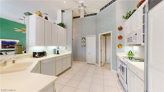 kitchen featuring white cabinetry, sink, ceiling fan, white appliances, and light tile patterned floors