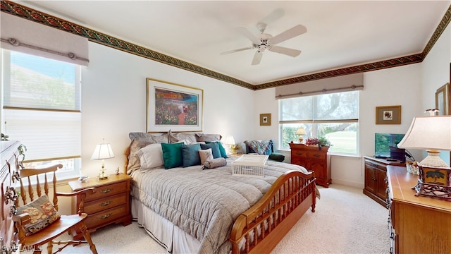 carpeted bedroom featuring multiple windows and ceiling fan