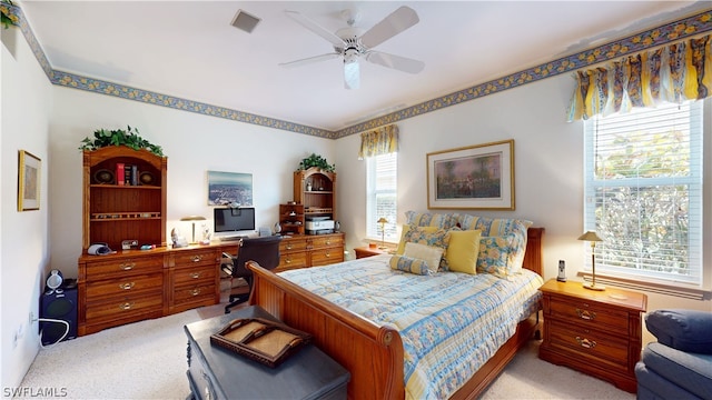 bedroom with light carpet, multiple windows, and ceiling fan