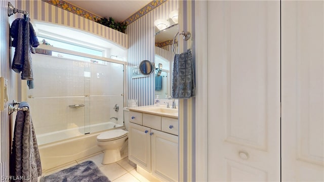 full bathroom with tile patterned floors, vanity, toilet, and bath / shower combo with glass door