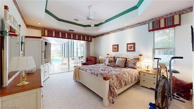 bedroom featuring access to outside, ceiling fan, a tray ceiling, and light colored carpet