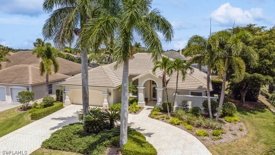 mediterranean / spanish-style house with a garage and a front yard