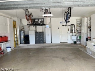 garage with white refrigerator, a garage door opener, and water heater